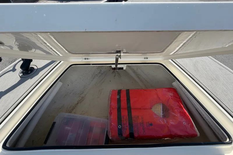 Slide: The Image of Open storage compartment on 2022 Hewes Redfisher 16 boat with life jacket and gear. - 31