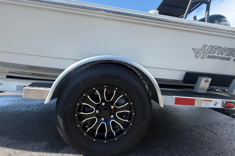Slide: The Image of 2022 Hewes Redfisher 16 boat on trailer, showcasing wheel and side view. - 64