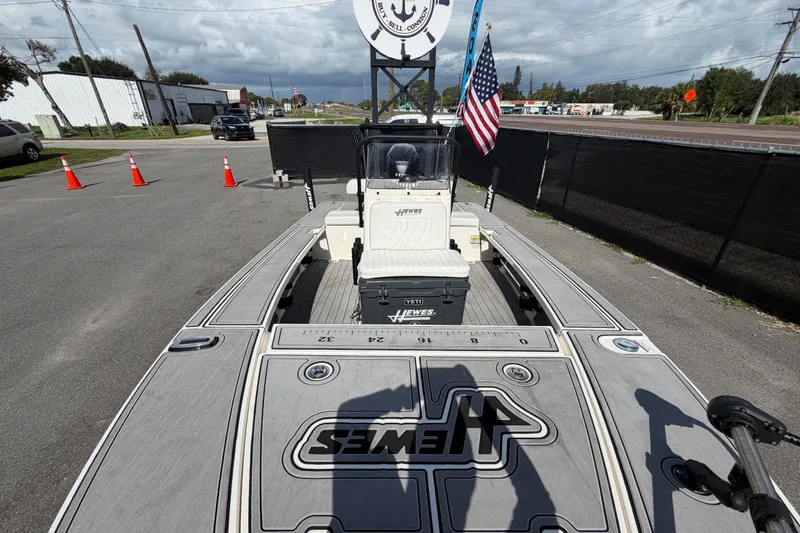 Slide: The Image of 2022 Hewes Redfisher 16 boat with American flag, parked on a street. - 36