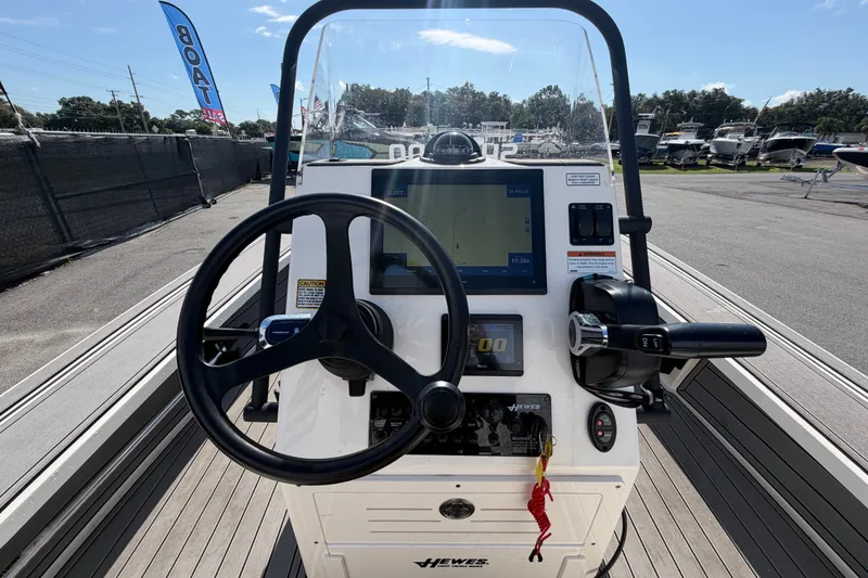 Slide: The Image of 2022 Hewes Redfisher 16 boat dashboard with steering wheel and navigation controls. - 18