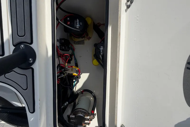 Slide: The Image of 2022 Hewes Redfisher 16 boat compartment with wiring and electrical components. - 50
