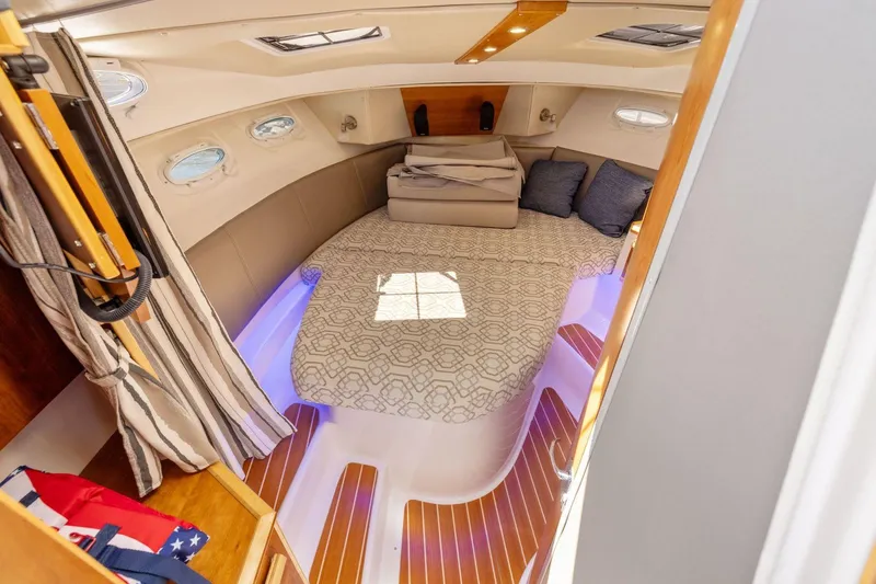 Slide: The Image of 2022 Cutwater C-32 CB cabin interior with cozy bed and ambient lighting. - 24