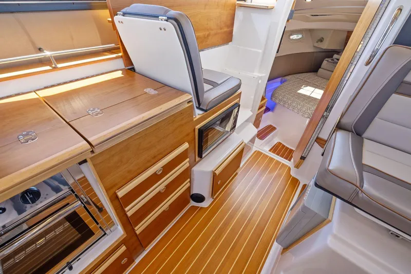 Slide: The Image of 2022 Cutwater C-32 CB interior with wood cabinetry and seating, showcasing luxury design. - 21