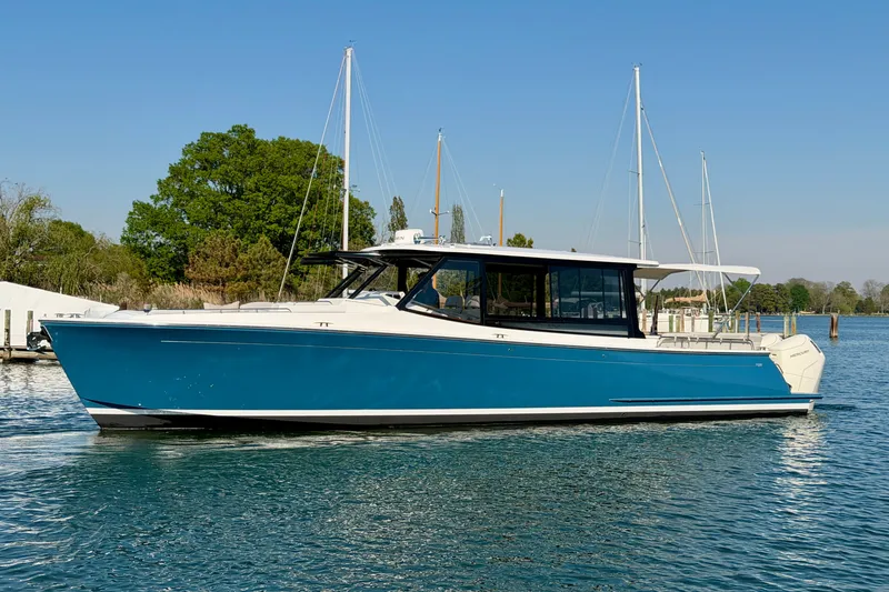Slide: The Image of 2025 MJM 4 boat on water, blue hull, sleek design, sunny day. - 10