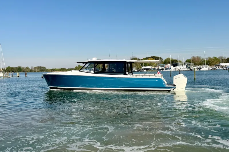 Slide: The Image of 2025 MJM 4 boat cruising on a calm lake under clear blue skies. - 9