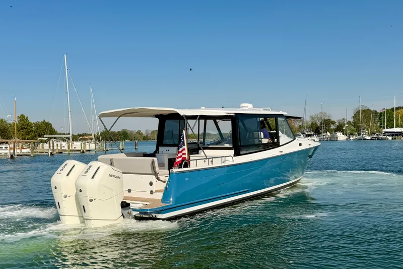 Slide: The Image of 2025 MJM 4 boat cruising on a sunny day with twin Mercury engines. - 4