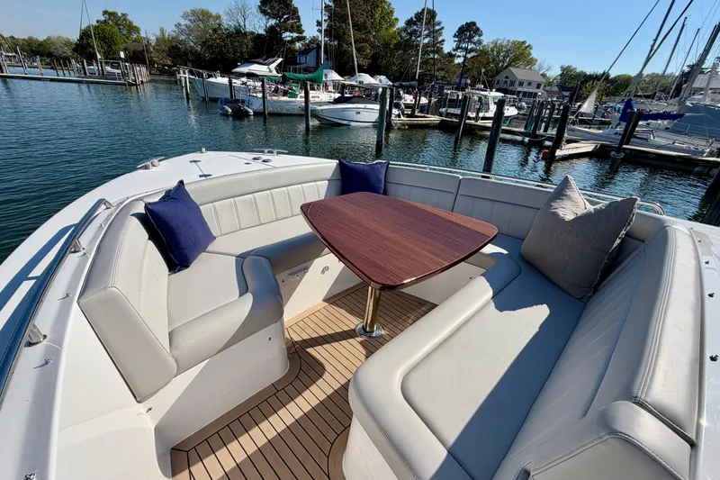 Slide: The Image of Luxurious 2025 MJM 4 boat with elegant seating and wooden table in a marina setting. - 30