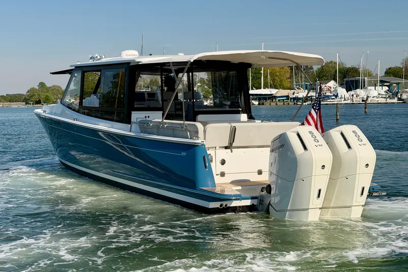 Slide: The Image of 2025 MJM 4 boat with dual Mercury V12 engines on a serene waterway. - 7