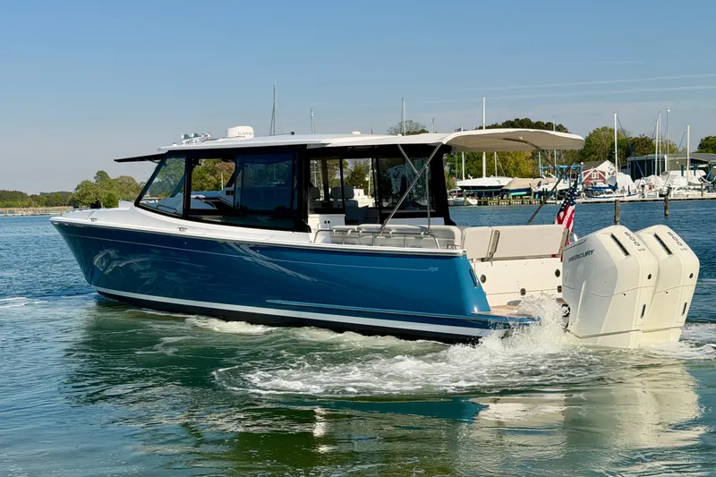 Slide: The Image of 2025 MJM 4 boat cruising on water with twin Mercury outboard engines. - 8