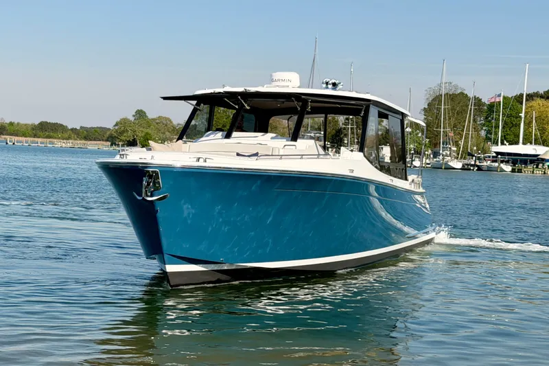 Slide: The Image of 2025 MJM 4 boat cruising on a serene lake with clear skies. - 12