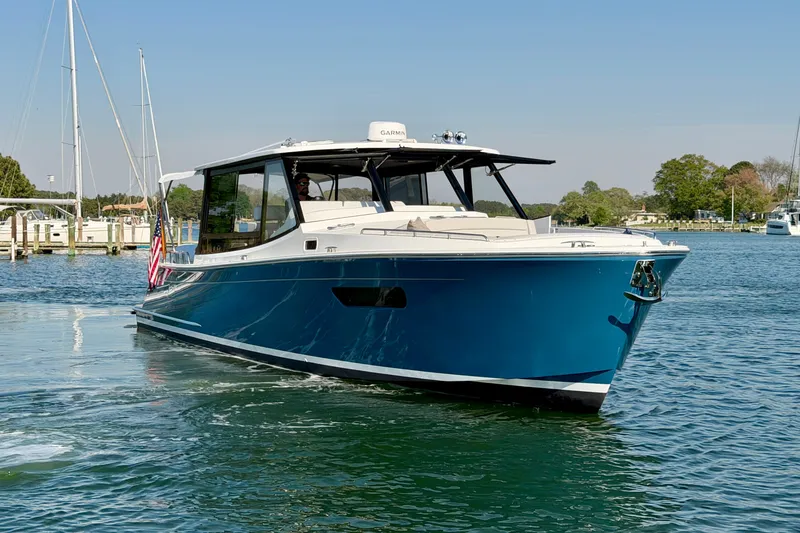 Slide: The Image of 2025 MJM 4 boat cruising on a calm lake with clear blue skies. - 16