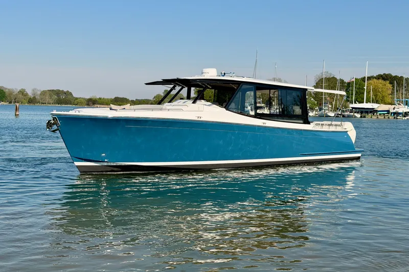 Slide: The Image of 2025 MJM 4 boat on calm water, showcasing sleek design and vibrant blue color. - 11