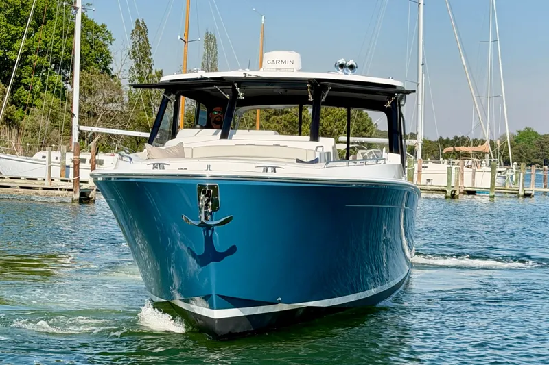 Slide: The Image of 2025 MJM 4 boat cruising in a marina, featuring sleek blue hull design. - 14