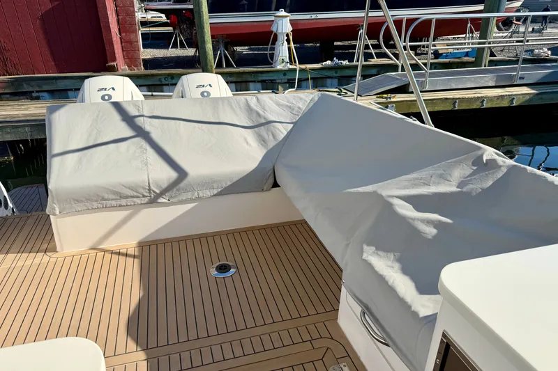 Slide: The Image of 2025 MJM 4 boat deck with covered seating and twin outboard engines at dock. - 47