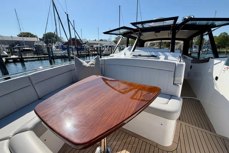 Slide: The Image of Luxurious 2025 MJM 4 yacht interior with elegant wood table and plush seating at marina. - 33
