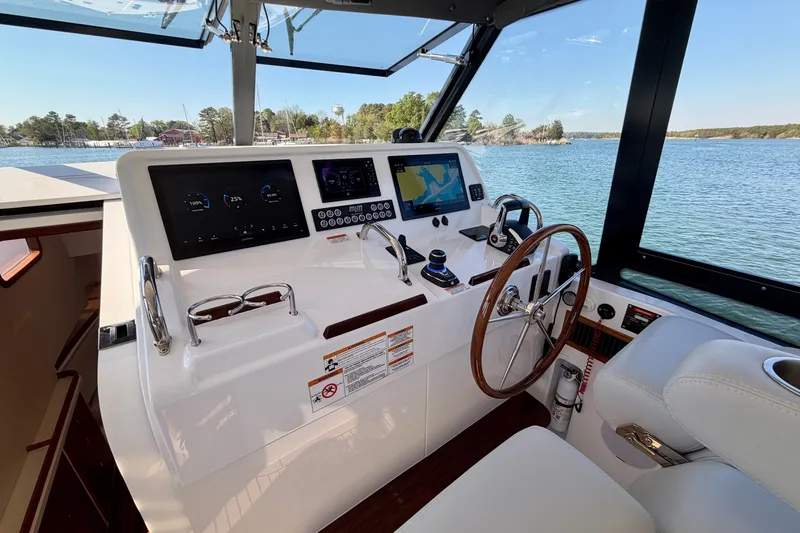 Slide: The Image of Helm of 2025 MJM 4 boat with modern navigation displays and wooden steering wheel. - 25