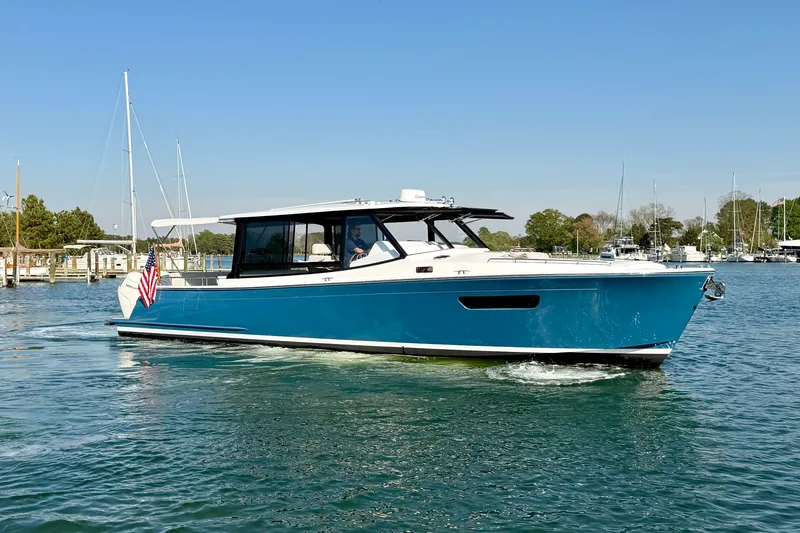 The Image of 2025 MJM 4 boat cruising on a sunny day in a marina. - 0