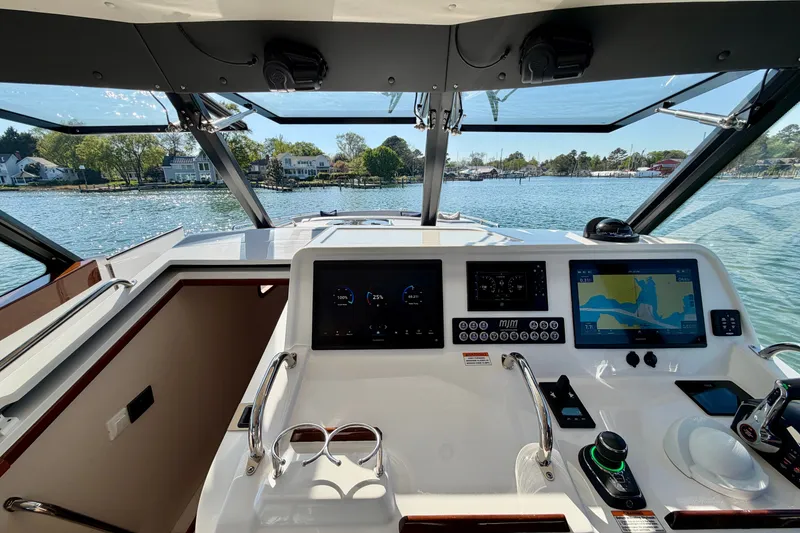 Slide: The Image of 2025 MJM 4 boat cockpit with advanced navigation displays and scenic waterfront view. - 26