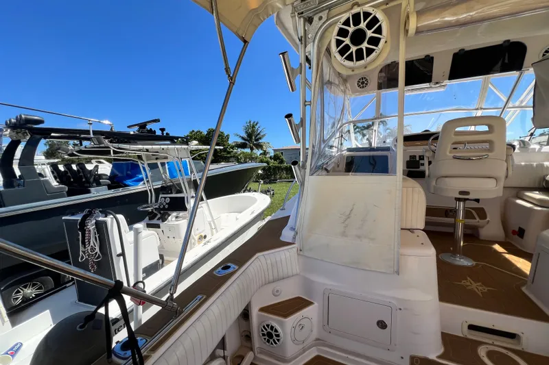 Slide: The Image of 2006 Grady-White Express 330 boat interior with seating and controls, under clear blue sky. - 21