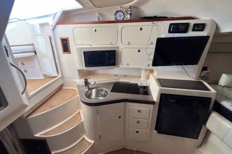 Slide: The Image of 2006 Grady-White Express 330 boat interior with kitchenette, microwave, and sink. - 27