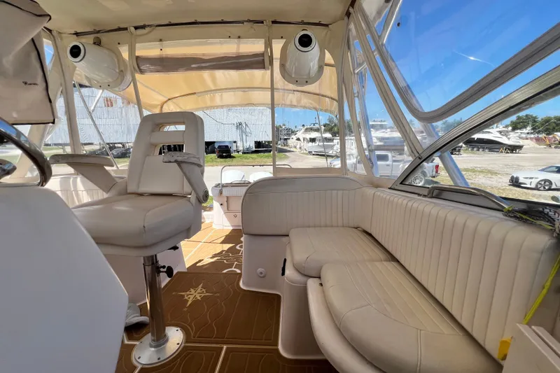 Slide: The Image of Interior of a 2006 Grady-White Express 330 boat with beige seating and clear windows. - 36