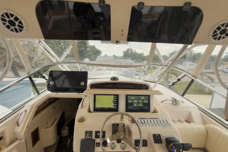 Slide: The Image of 2006 Grady-White Express 330 boat cockpit with navigation screens and steering wheel. - 31