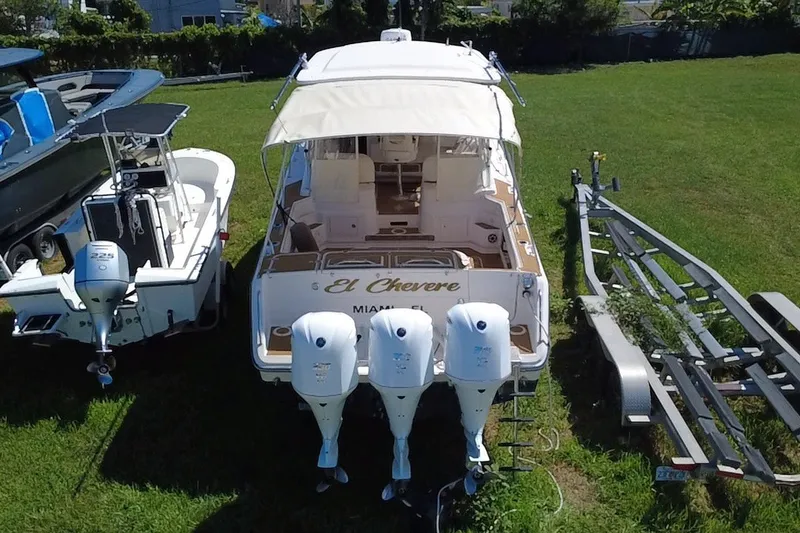 Slide: The Image of 2006 Grady-White Express 330 boat with triple outboard engines on grass. - 2