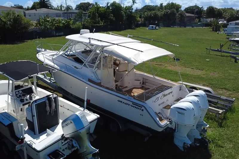 Slide: The Image of 2006 Grady-White Express 330 boat with twin Yamaha engines on grassy lot. - 8