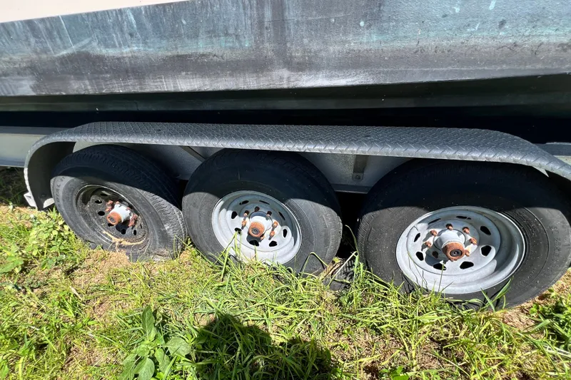 Slide: The Image of Trailer wheels of a 2006 Grady-White Express 330 boat on grass. - 71
