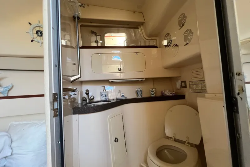 Slide: The Image of 2006 Grady-White Express 330 boat bathroom with sink, toilet, and storage cabinets. - 32