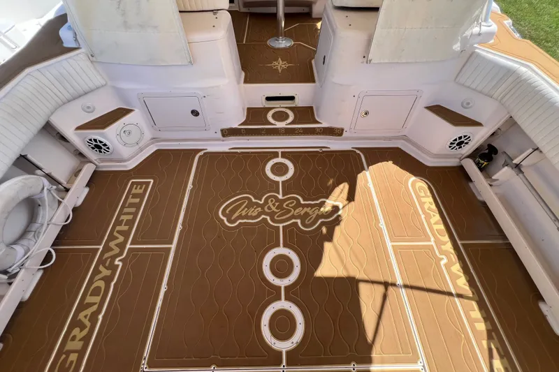 Slide: The Image of 2006 Grady-White Express 330 boat deck with custom brown flooring and white seating. - 20