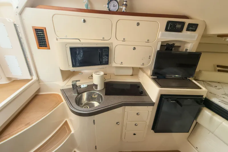 Slide: The Image of 2006 Grady-White Express 330 boat interior with kitchenette, sink, microwave, and storage cabinets. - 21