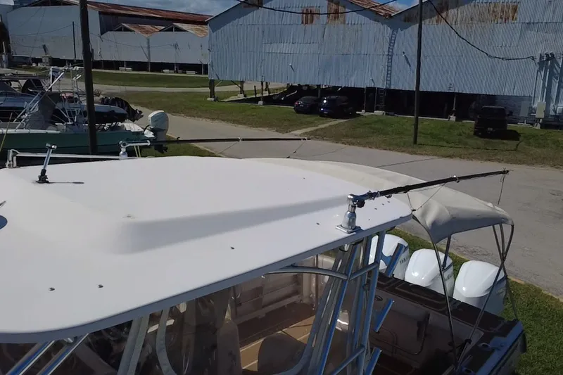 Slide: The Image of 2006 Grady-White Express 330 boat with fishing rods, docked near industrial buildings. - 9