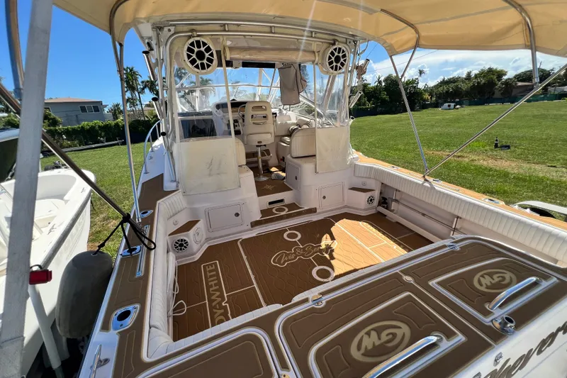 Slide: The Image of 2006 Grady-White Express 330 boat interior with seating and canopy, parked on grass. - 56