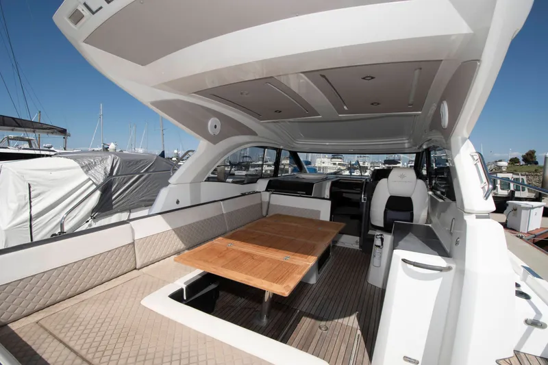 Slide: The Image of The image shows the cockpit of a 2018 Jeanneau Leader 33 with a wooden table and cushioned seating. - 8