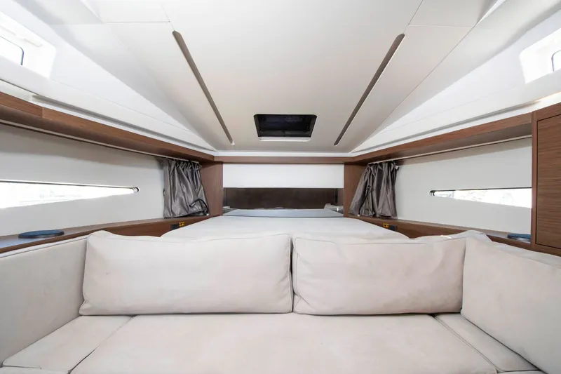 Slide: The Image of Interior of a 2018 Jeanneau Leader 33 featuring a beige sofa and a bed. - 1