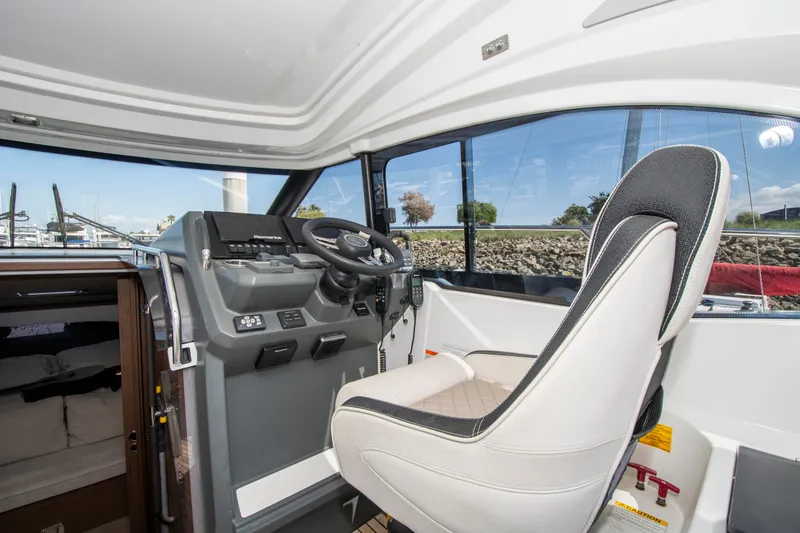 Slide: The Image of The cockpit of a 2018 Jeanneau Leader 33 with a modern helm and a comfortable seat. - 10