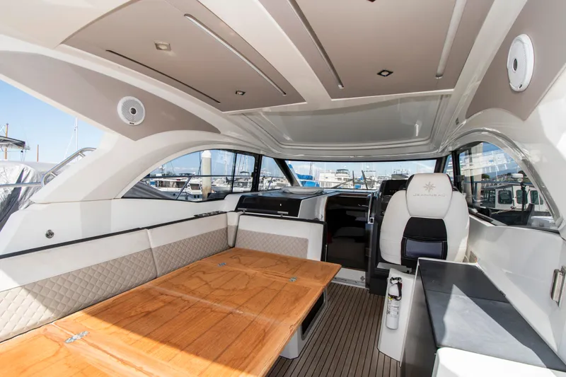 Slide: The Image of Interior of a 2018 Jeanneau Leader 33 with a wooden table and cushioned seating. - 9
