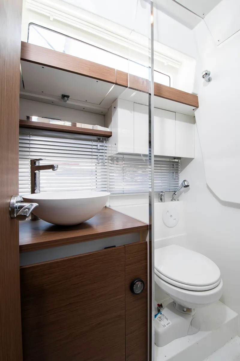 Slide: The Image of The image shows a modern boat bathroom with a sink, toilet, and wood paneling. - 3