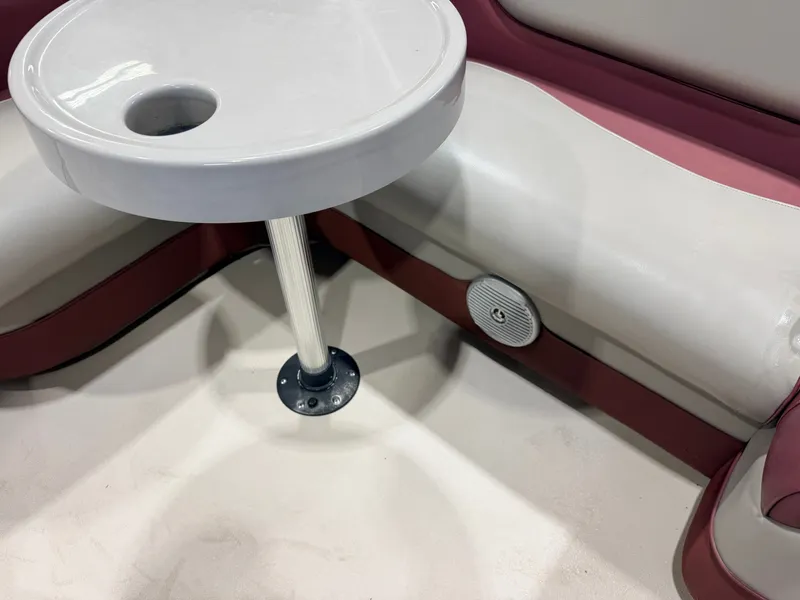 Slide: The Image of A round table with a cup holder on a boat with red and white seating. - 27