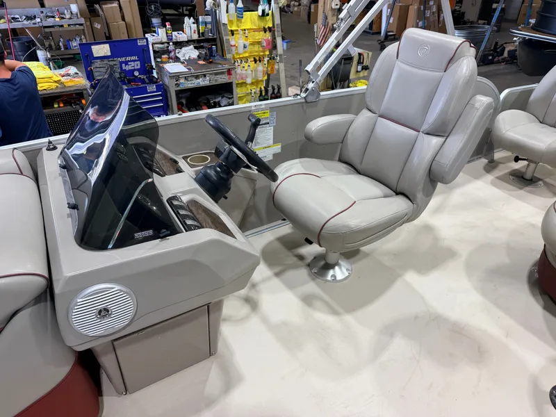 Slide: The Image of The image shows the helm of a 2014 Premier 221 Gemini Fish n Cruise boat with a comfortable captain's chair. - 14