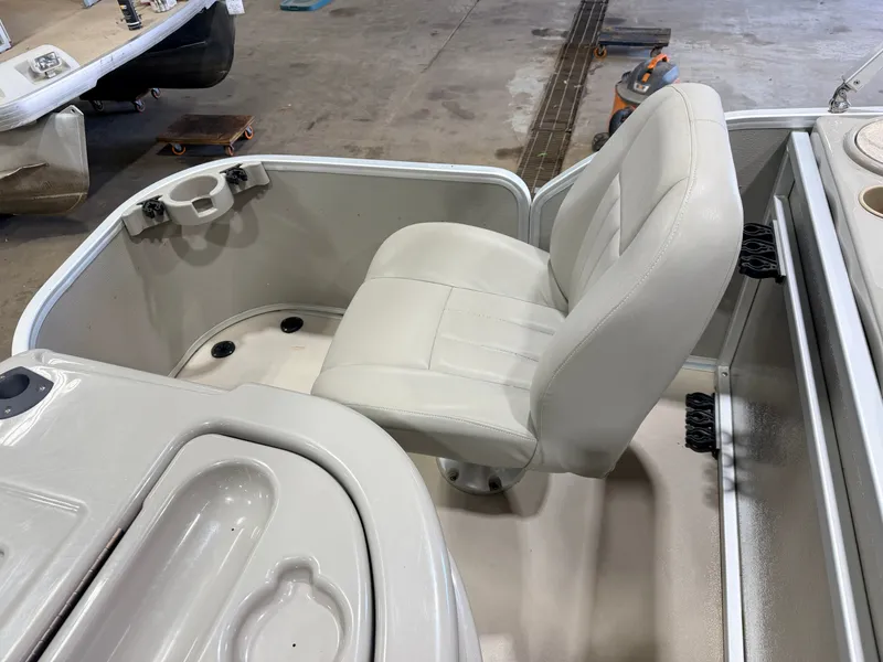 Slide: The Image of A white seat in a boat with a gray floor and a cup holder. - 39