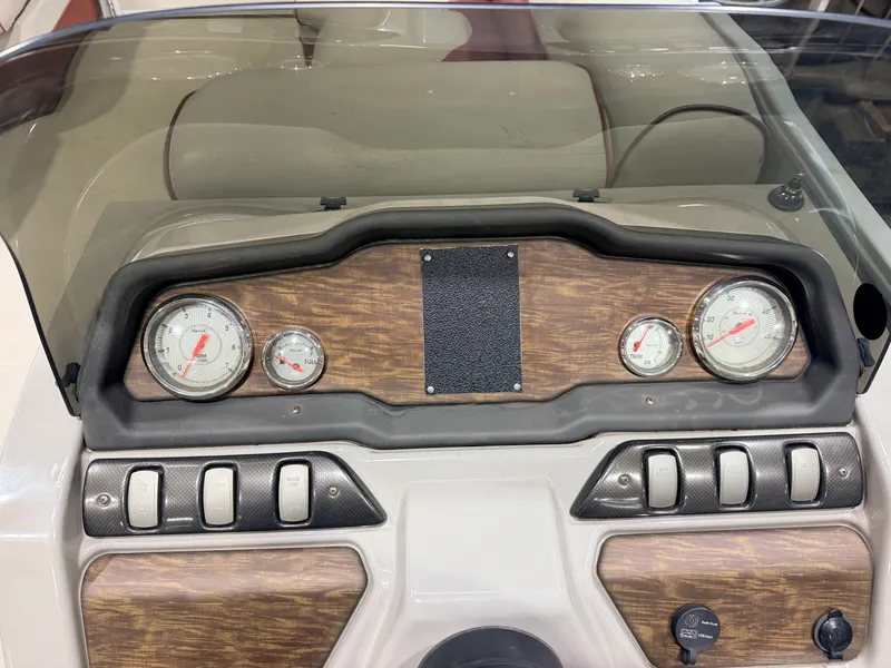 Slide: The Image of The image shows a boat dashboard with wood paneling and several gauges. - 17