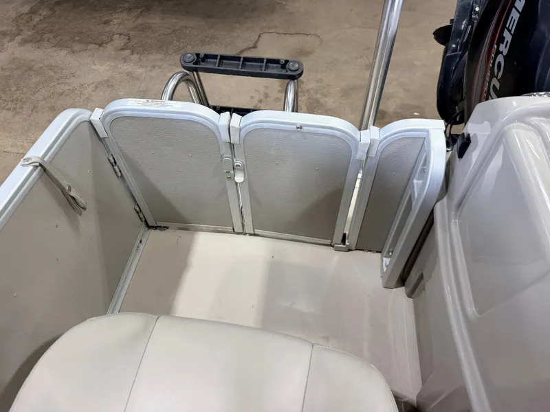 Slide: The Image of The image shows the interior of a 2014 Premier 221 Gemini Fish n Cruise boat. Visible are seating and a Mercury 4Stroke engine. - 33