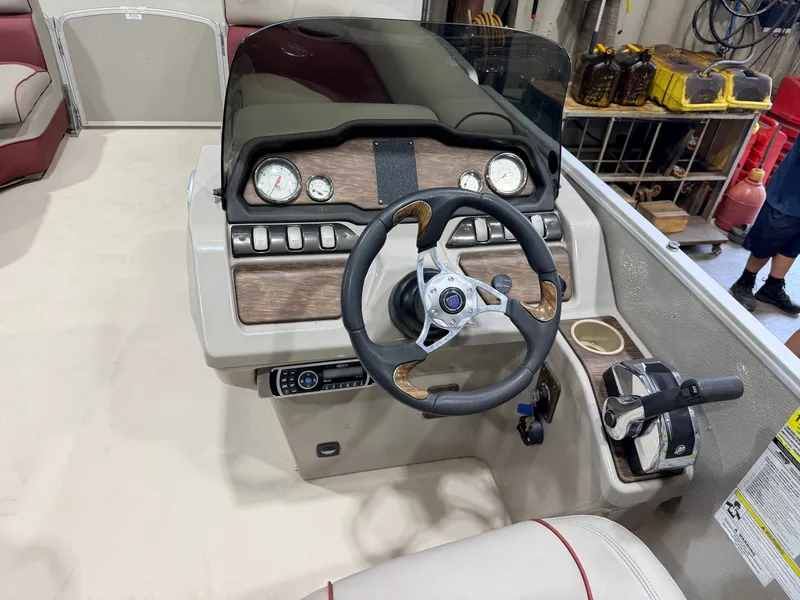 Slide: The Image of The image shows the helm of a 2014 Premier 221 Gemini Fish n Cruise boat. - 16
