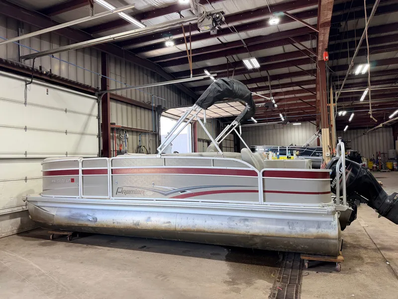 Slide: The Image of A 2014 Premier 221 Gemini Fish n Cruise pontoon boat with a 50HP Mercury 4Stroke engine in a warehouse. - 50