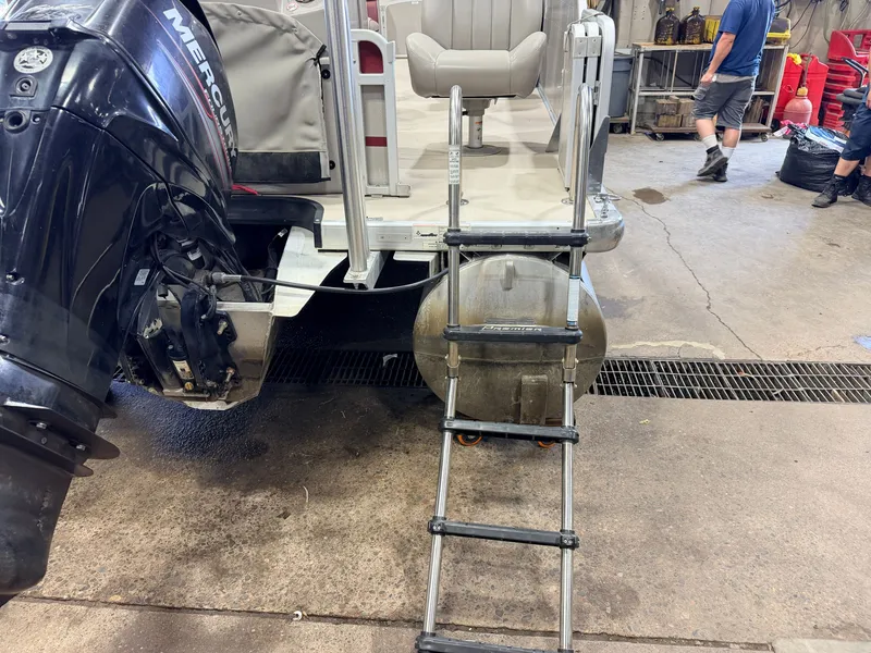 Slide: The Image of A 2014 Premier 221 Gemini Fish n Cruise with a 50HP Mercury 4Stroke engine. A ladder leads into the boat. - 31