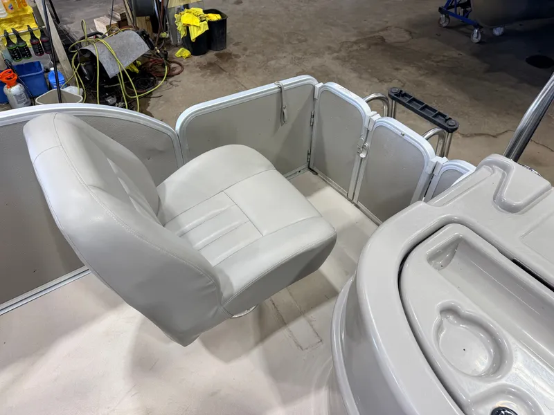 Slide: The Image of A gray seat on a boat with gray walls and a helm console. - 44