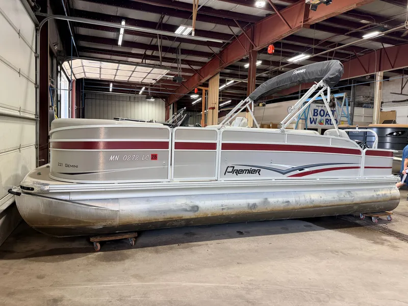 Slide: The Image of A 2014 Premier 221 Gemini Fish n Cruise pontoon boat with a 50HP Mercury 4Stroke engine in a warehouse. - 48