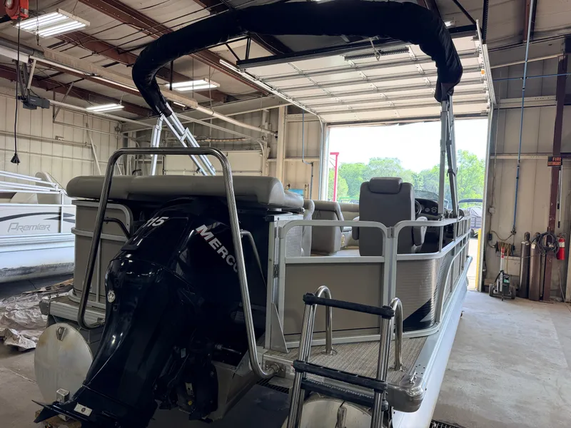 Slide: The Image of A 2007 Premier 210 Legend pontoon boat in a warehouse. It features a Mercury outboard motor. - 42